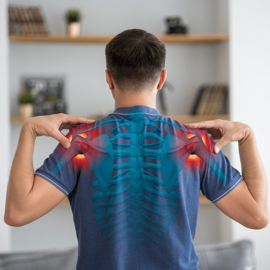 Rear view of a man in a blue shirt touching both shoulders with highlighted red areas indicating pain points in the shoulders.