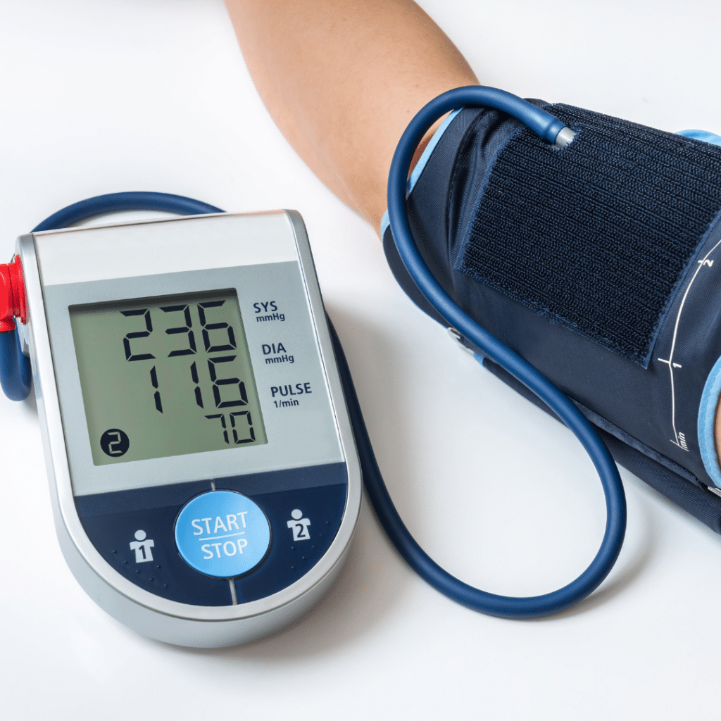 Blood pressure monitor displaying a reading of 230/116 on a patient's arm.