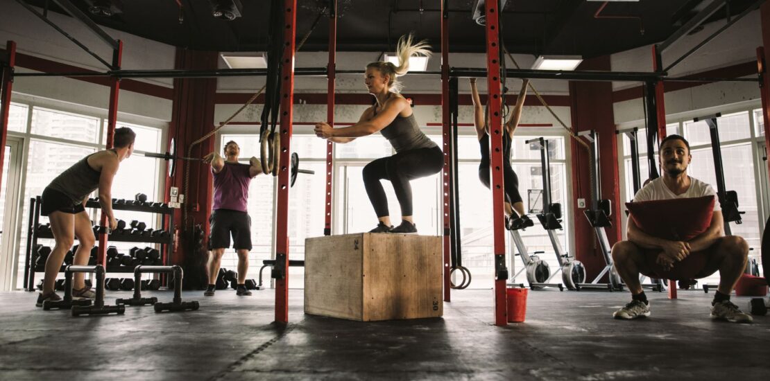 Group of five people engaging in functional training exercises in a dynamic workout class, focused on building strength, mobility, and everyday movement skills.